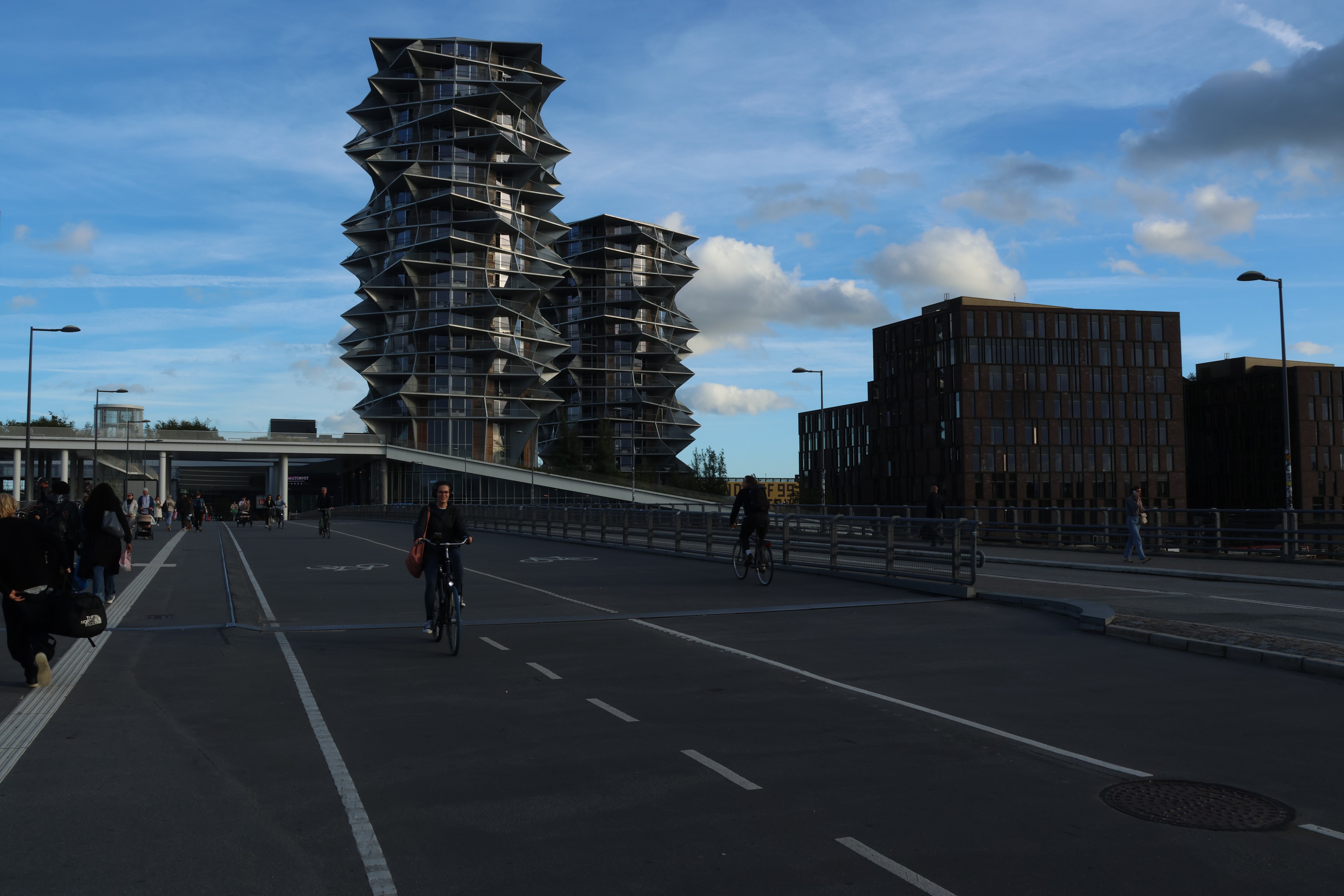 Cyclists on the bridge below the serrated balconies of the Cactus Towers