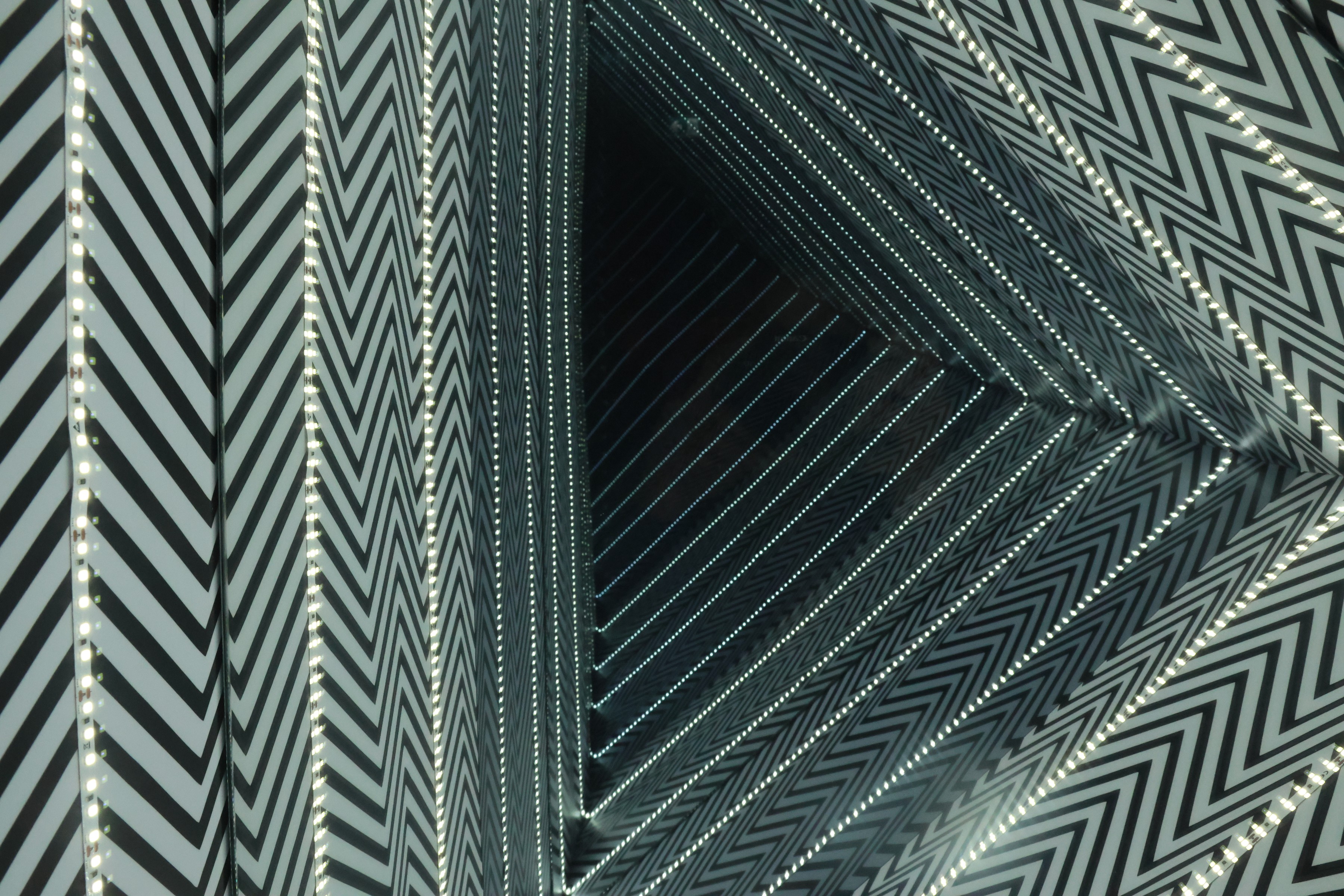 Chevron-striped panels and strings of lights folding into a tunnel