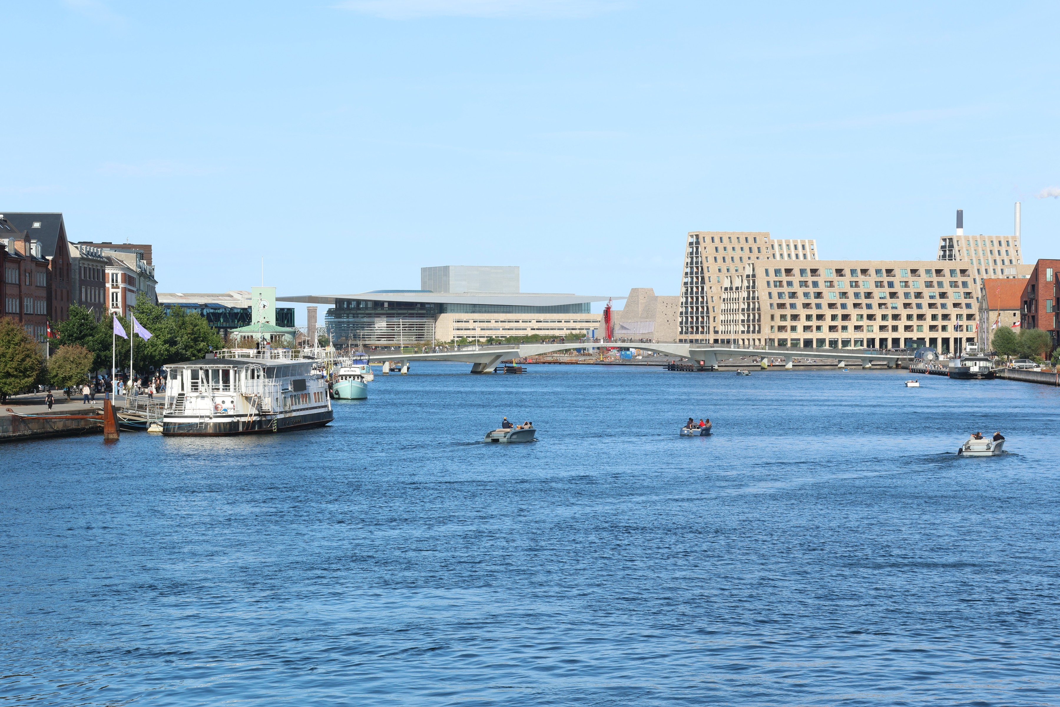 Small boats on the inner harbour with a footbridge and the Playhouse beyond