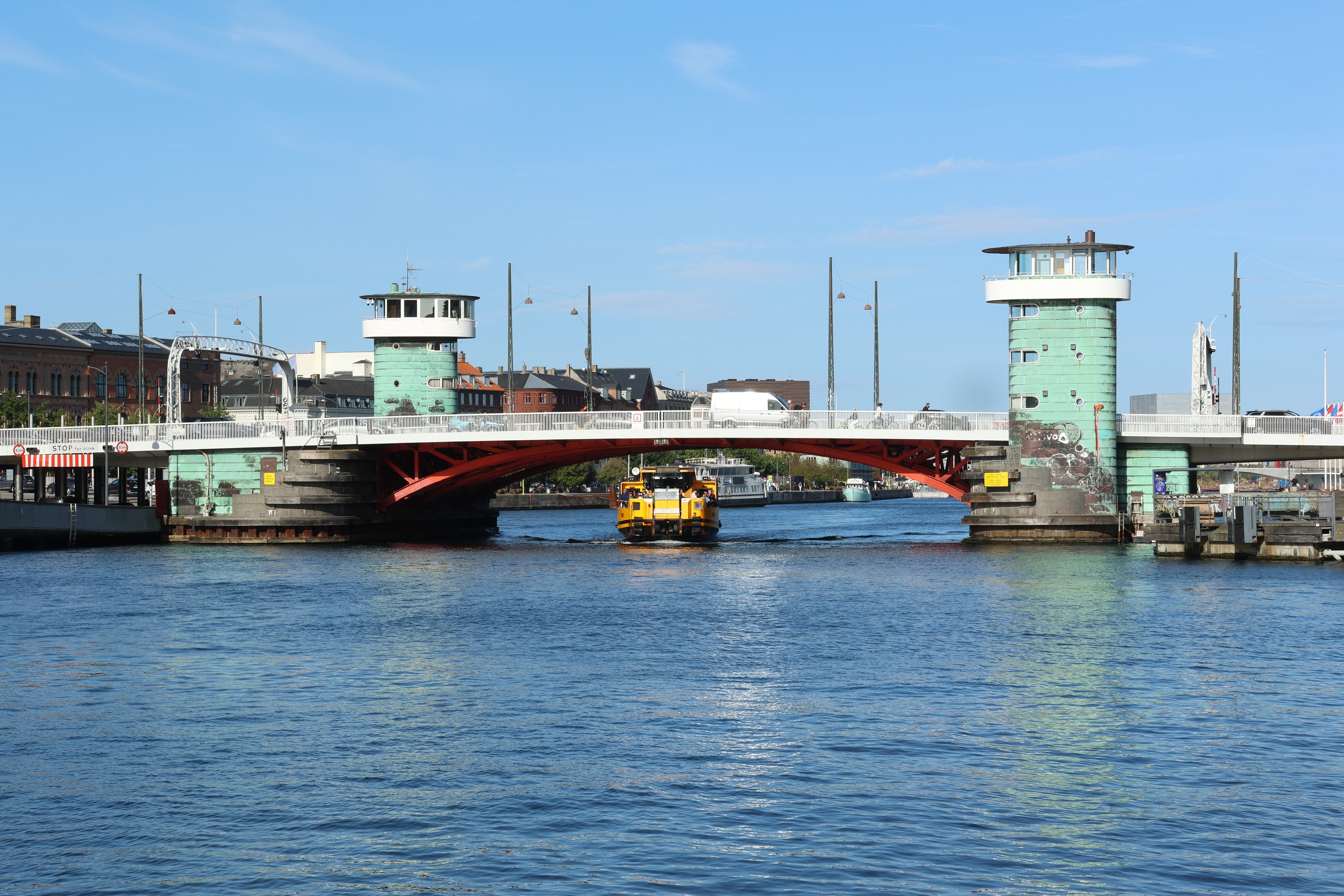 A workboat passing under the red span and green towers of Knippelsbro